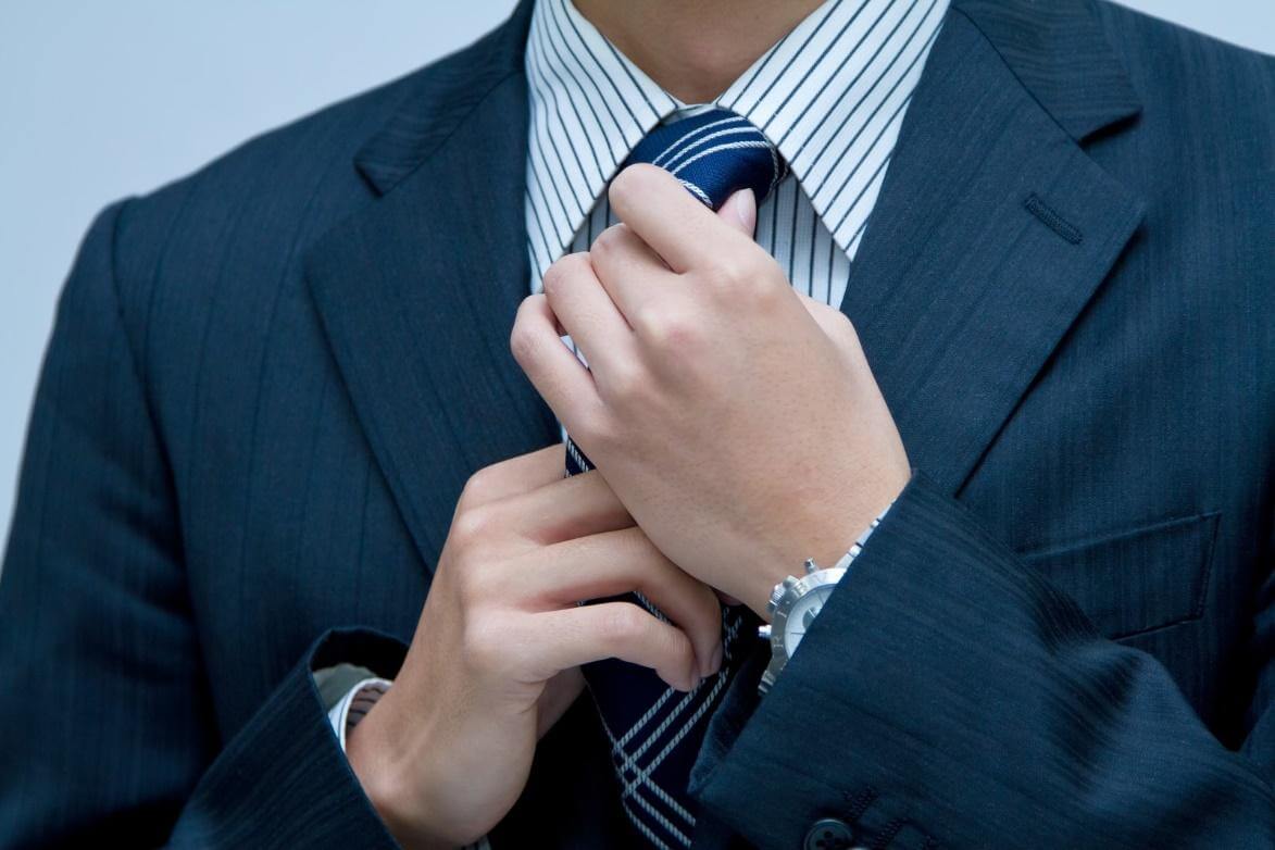 ネクタイをしめるスーツ姿の男性